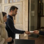 Visitors receiving tickets at the entrance desk of a historic museum in Iran
