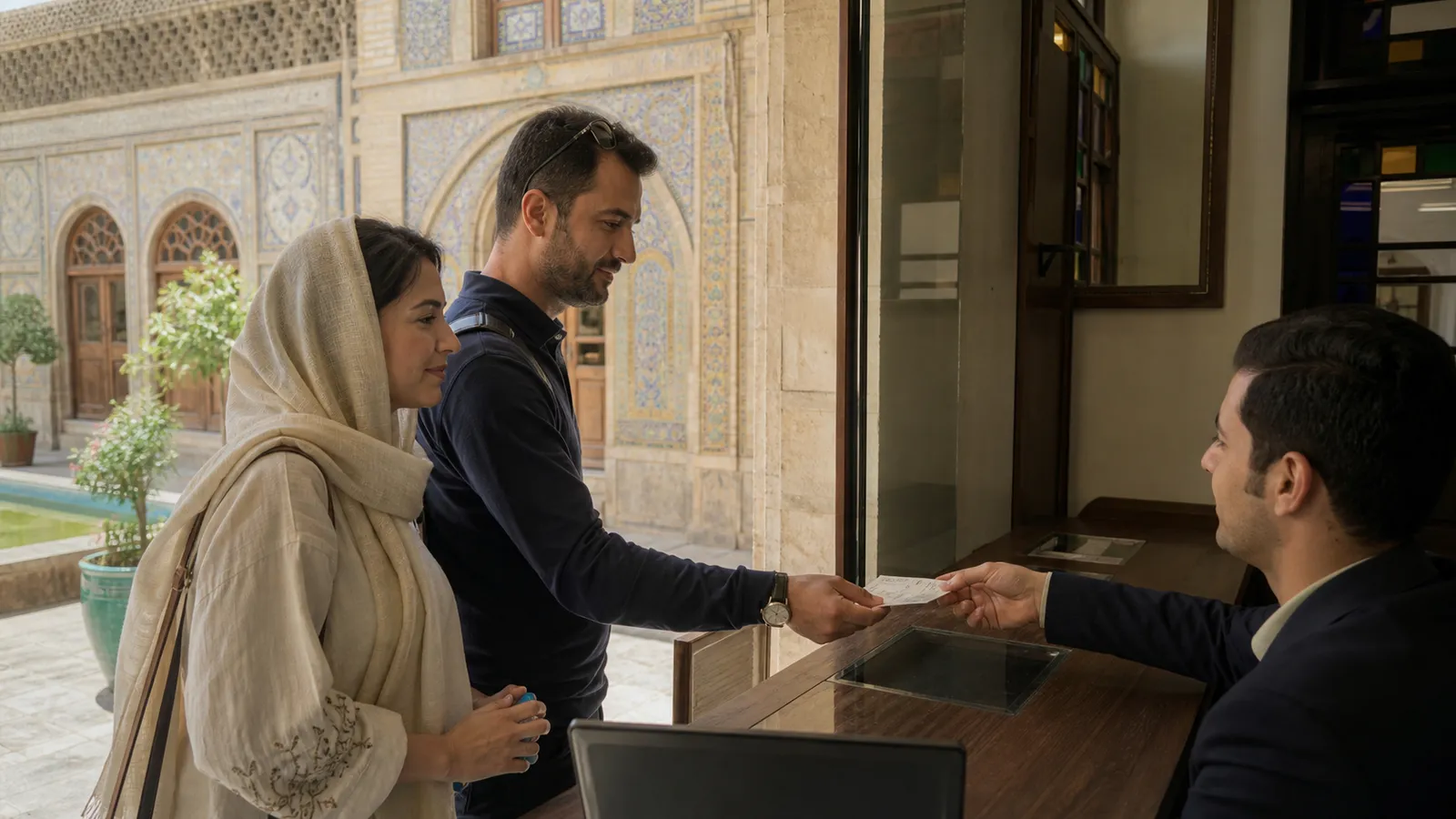 Visitors receiving tickets at the entrance desk of a historic museum in Iran