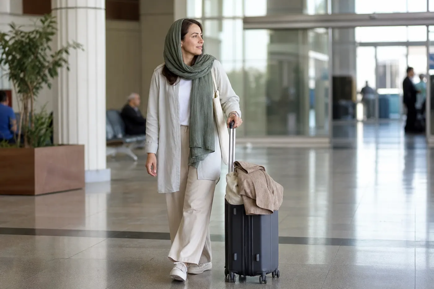Female traveller wearing an adaptable layered outfit with scarf ready for arrival in Iran